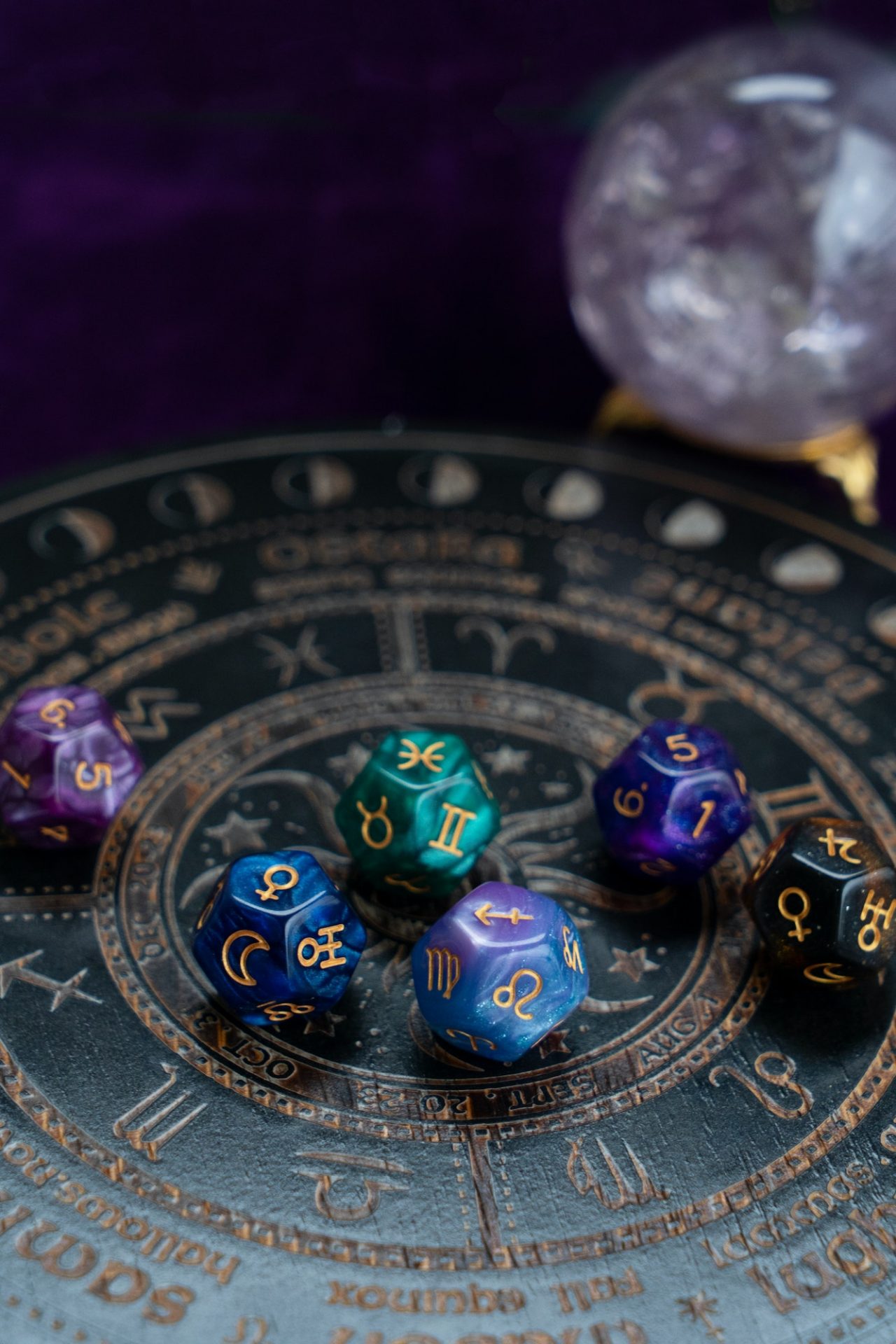 Colorful astrological dice arranged on a circular zodiac chart, with a crystal sphere in the background. The image conveys themes of spirituality and guidance.